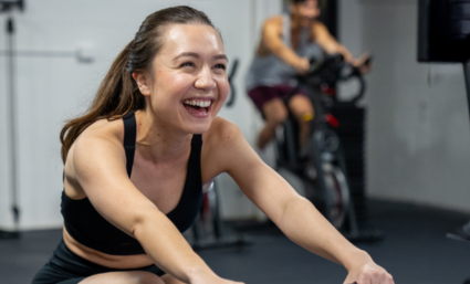 Woman sitting on a workout rower and smiling