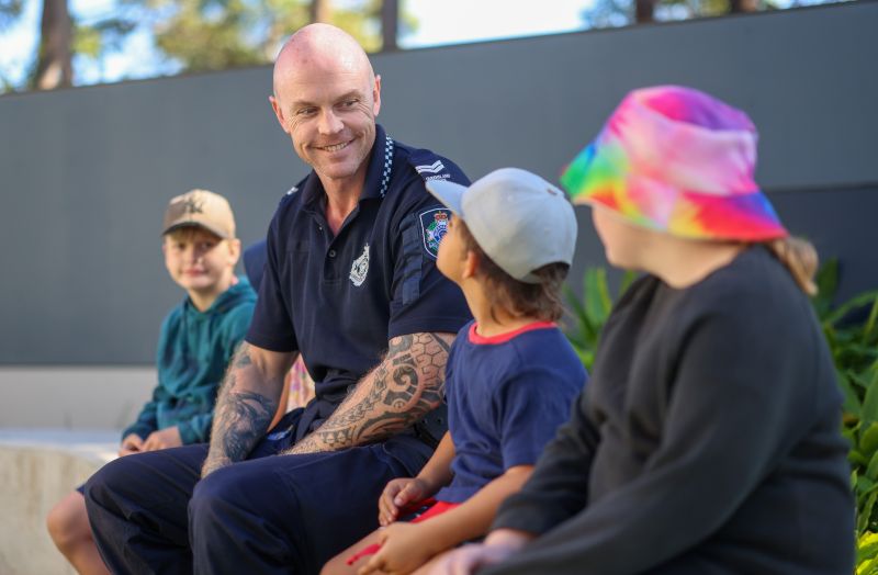 QPS officer sat with 3 children
