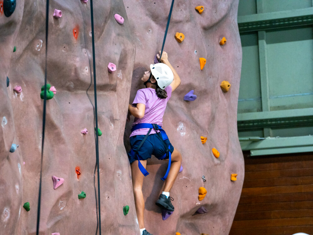 Girl participating in indoor rock climbing