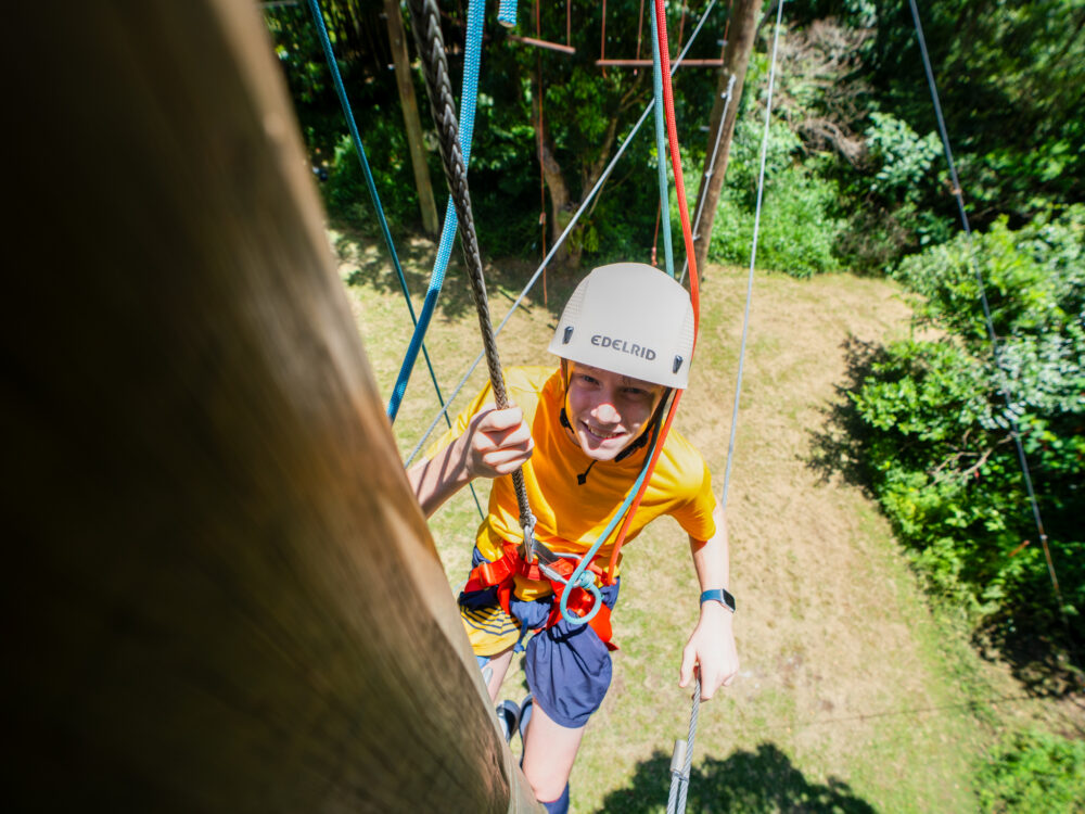 teen doing treetop adventure course