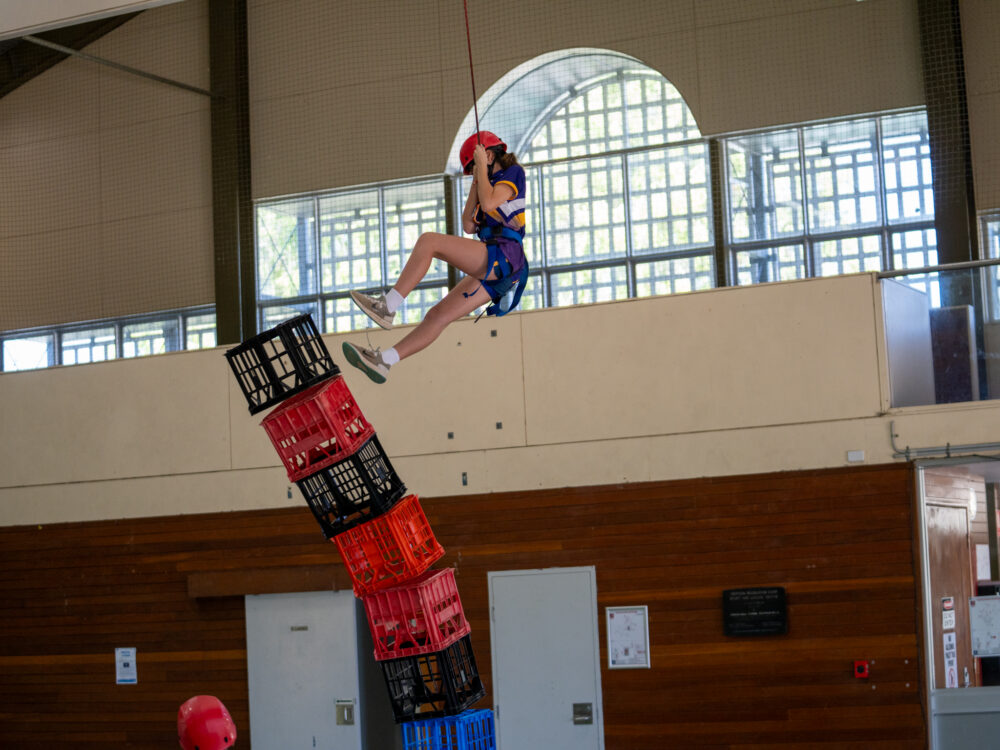 Girl swinging from rope while completing a challenge