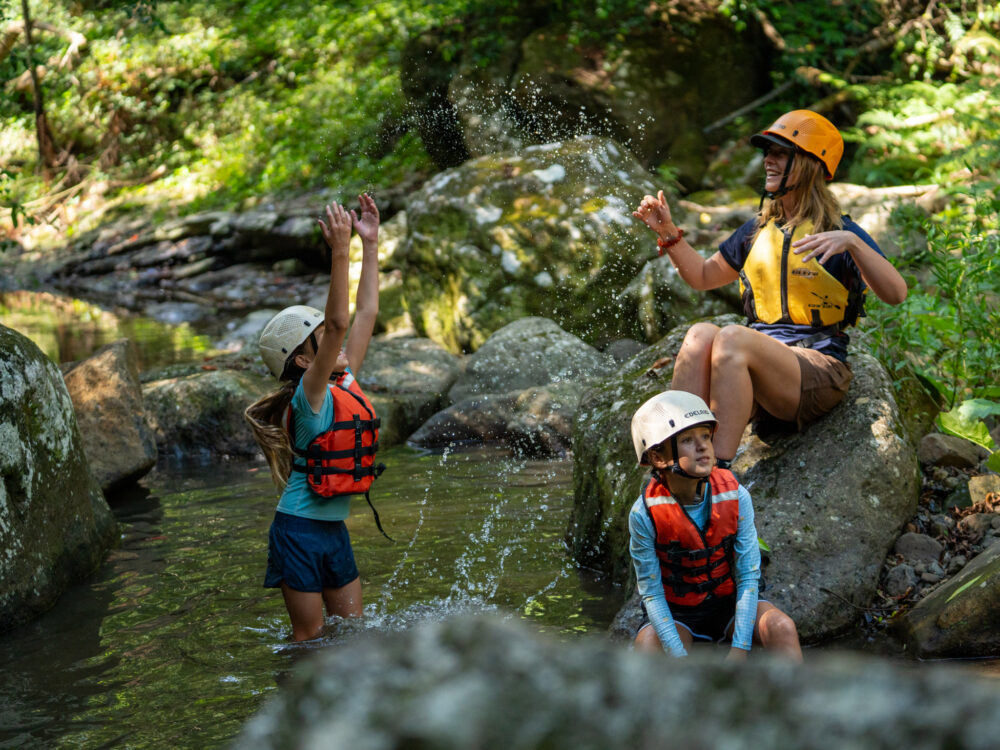 Kids splashing and playing in the river with PCYC Staff