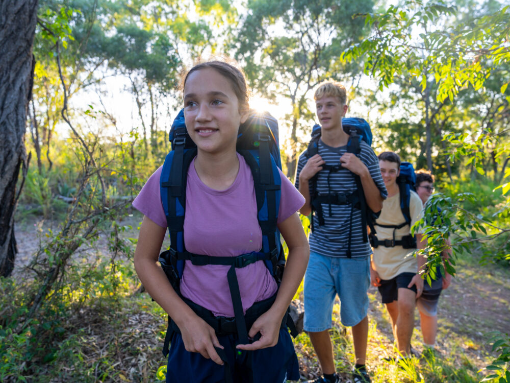 Teens trekking through forest